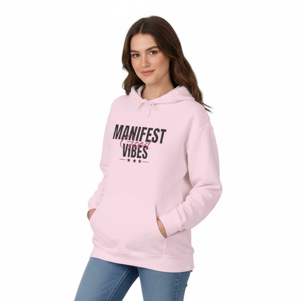 Woman wearing a Light Pink hoodie with 'Manifest Good Vibes' text on a white background